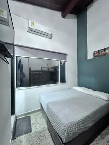 a bedroom with a bed and a large window at Living Hotel in Medellín