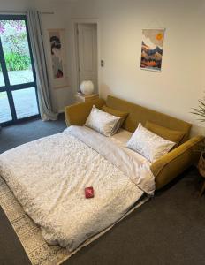 a large bed in a room with a couch at Nelson Escape in Nelson