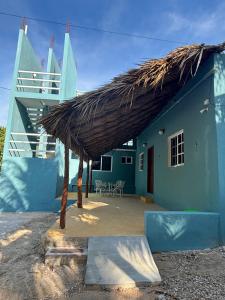 a blue house with a thatched roof and a patio at Casa GLEZAR el cuyo in El Cuyo +7 photos