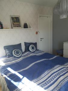 ein blau-weißes Bett mit blauen Kissen darauf in der Unterkunft Synnseter in Nord Torpa