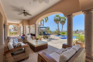 an open living room with a patio with palm trees at The Fairway Villa in San José del Cabo