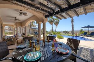 a patio with a table and chairs and a pool at The Fairway Villa in San José del Cabo
