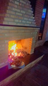a brick fireplace with a fire in it at Serra mineira in Resende