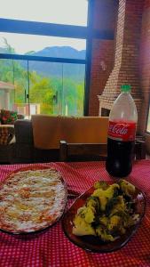 two plates of food and a bottle of soda on a table at Serra mineira in Resende