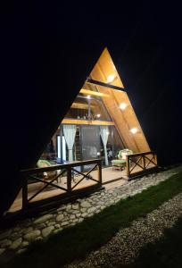 a large wooden house with a porch at night at Cabanele Avoca in Avrig +16 photos