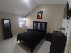 a bedroom with a black bed in a room at Floresta in Manuel F. Martínez