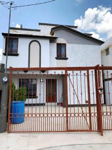 a white house with a wooden gate in front of it at Floresta in Manuel F. Martínez