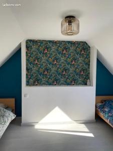 a room with two beds and a chandelier at Charmant penty pour un séjour calme et reposant in Ergué-Gabéric