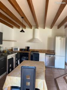 a kitchen with a table and a refrigerator at Charmant penty pour un séjour calme et reposant in Ergué-Gabéric
