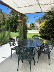 a patio table and chairs under an umbrella at H Molle in Cafayate