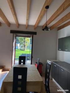 a kitchen with a table and chairs and a window at Charmant penty pour un séjour calme et reposant in Ergué-Gabéric +10 photos