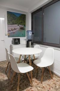 a white table and chairs in a room with a window at Villa 2VB in Shkodër