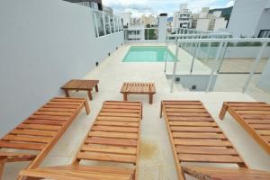 a balcony with benches and a swimming pool at Legui Suites in Salta