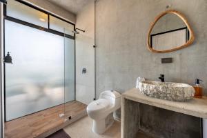 a bathroom with a sink and a toilet and a shower at Nelblu Flamingo Suites in Playa Flamingo