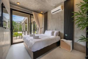 a bedroom with a large bed and a large window at Nelblu Flamingo Suites in Playa Flamingo