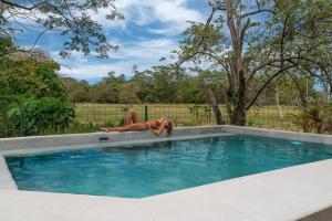 a woman laying on the edge of a swimming pool at Nelblu Flamingo Suites in Playa Flamingo