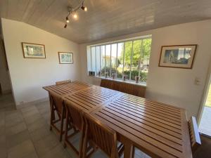a large wooden table in a room with a window at La Villa du Clocher in Saint-Clément-des-Baleines