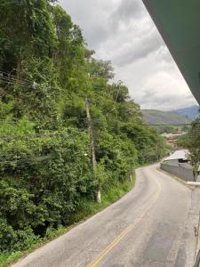 an empty road with trees on the side of the road at M&M Pousada in Petrópolis