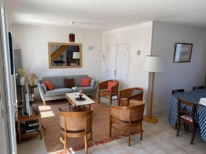 a living room with a couch and a table and chairs at La Villa de la Digue in Saint-Clément-des-Baleines