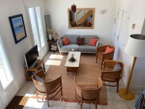 a living room with a couch and a table and chairs at La Villa de la Digue in Saint-Clément-des-Baleines