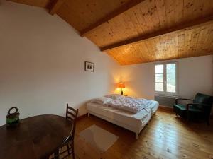 a bedroom with a bed and a table in a room at La Villa de la Digue in Saint-Clément-des-Baleines
