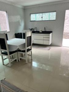 a kitchen with a table and two chairs and a sink at Cada da lanny in Camaçari