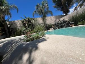 a swimming pool with a retaining wall and some plants at H Molle in Cafayate +17 photos