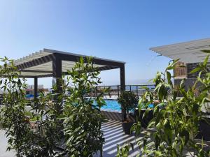 a swimming pool with a pergola and some plants at mass paradise2 in Aqaba