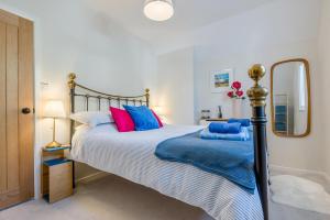 a bedroom with a bed with blue and pink pillows at 2 Bed in Wadebridge oc-m32567 in Wadebridge