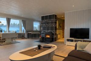 a living room with a couch and a fire place at House under the Aurora Cozy Private Home with Fireplace in Laukvik