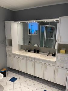 a bathroom with two sinks and a large mirror at House under the Aurora Cozy Private Home with Fireplace in Laukvik +34 photos