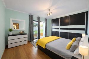 a bedroom with a large bed with a yellow blanket at Villa Vieira Ocean View in Gaula