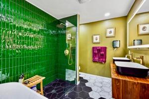 a green bathroom with a sink and a shower at The Railyard NOLA - Adult Only, Clothing Optional Pool in New Orleans