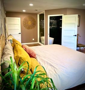 a bedroom with a large white bed with yellow pillows at The Railyard NOLA - Adult Only, Clothing Optional Pool in New Orleans