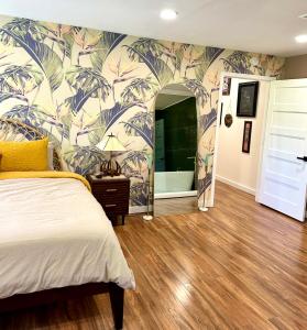 a bedroom with a mural of palm trees on the wall at The Railyard NOLA - Adult Only, Clothing Optional Pool in New Orleans