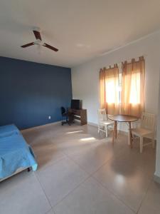 a bedroom with a bed and a table and chairs at Recanto das Violetas in Extrema