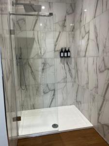 a bathroom with a shower with a glass door at Ascot House Apartment in Hurstpierpoint