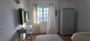 a bedroom with a bed and a dresser and a window at Callao de Sal in Mazo