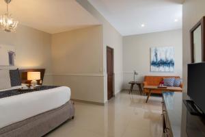 a hotel room with a bed and a couch at Hodelpa Caribe Colonial in Santo Domingo
