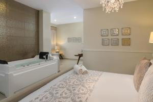 a bedroom with a bath tub and a bed at Hodelpa Caribe Colonial in Santo Domingo