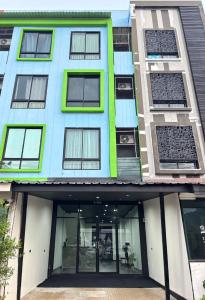 an apartment building with windows and a front entrance at Atrium Kathu Hotel in Ban Kathu (1)