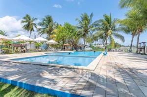 a pool at a resort with palm trees at Chales Maragogi in Maragogi