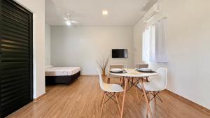 a room with a table and chairs and a bed at Studio 209-AP2 espaço completo ideal para casal in Ubatuba