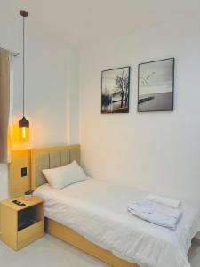 a bedroom with a bed and two pictures on the wall at KOH SAMUI - Apartamentos by Luxury Atitlan in San Pedro La Laguna