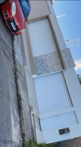a car parked next to a house with a garage at Cada da lanny in Camaçari