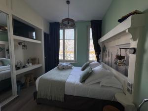 a bedroom with a bed and a window at Logis Hôtel- Restaurant Le Relais Guillaume de Normandy-PARKING GRATUIT--VUE BAIE TERRASSE-CALME-BORNES ELECTRIQUE-LOCAL VELOS SÉCURISÉ in Saint-Valéry-sur-Somme