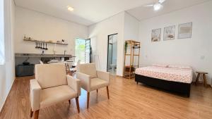 a bedroom with a bed and a table and chairs at Studio 209-AP2 espaço completo ideal para casal in Ubatuba