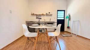 a dining room with a white table and white chairs at Studio 209-AP2 espaço completo ideal para casal in Ubatuba +11 photos