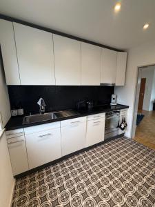 eine Küche mit weißen Schränken und einer Spüle in der Unterkunft Modernes Dachgeschossapartment in Singen Zentrum in Singen