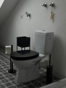 ein Badezimmer mit einer Toilette mit schwarzem Sitz in der Unterkunft Modernes Dachgeschossapartment in Singen Zentrum in Singen